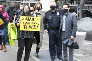 a group of four people with covid masks holding a hate has no place sign