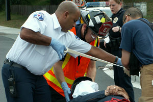 Firefighters and paramedics attend to a patient.