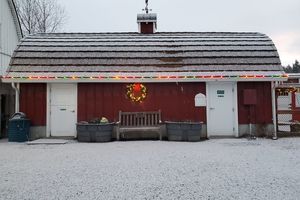 Red barn with holiday lights on gutter line