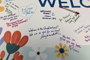 Photo of a section of banner that says "You are welcome here". Individual handwritten messages are written on the banner.