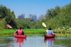 two people kayaking separately in clam slough waters