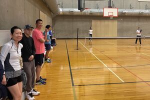people waiting on sidelines of pickleball court