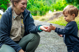Bellevue park ranger shows a child an acorn during a nature walk