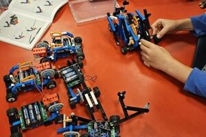 A child follows instructions to assemble a robotic toy car