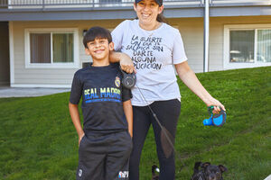 Woman and child in front of housing.