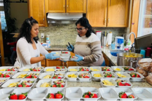 two people in a kitchen preparing  meals