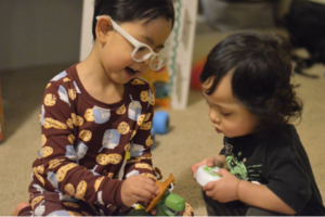 two toddlers play with toys together