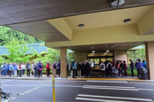 A line of people waiting outside of a building
