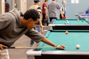young man plays billiards at Crossroads Community Center games room
