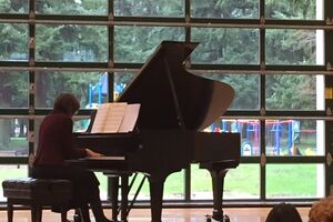 woman plays piano in front of an audience