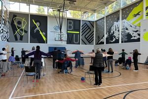 A group of people in a gym copying fitness instructors poses