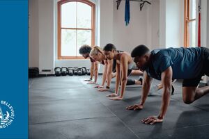 group of people in a fitness class in various push-up positions